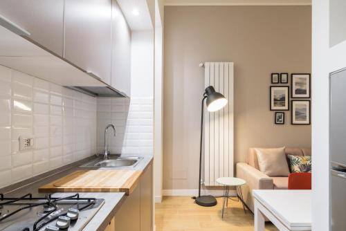 eine Küche mit einem Waschbecken und ein Wohnzimmer mit einem Sofa in der Unterkunft Fantoni Suite in Mailand