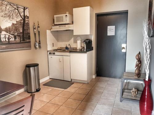 cocina pequeña con fogones y microondas en Cozy 1-Bedroom Suite #17 by Amazing Property Rentals, en Gatineau