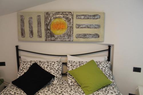 1 dormitorio con 1 cama con almohadas y una pintura en la pared en Guardando le stelle en Vernazza