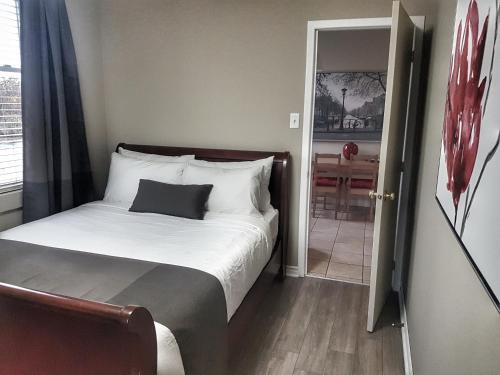 a bedroom with a bed and a door to a room at Cozy 2-Bedroom Apartment #25 by Amazing Property Rentals in Gatineau