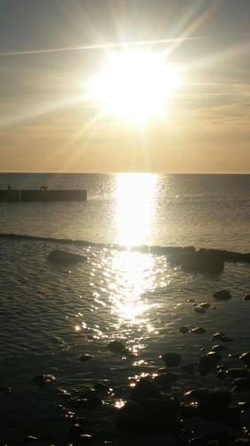 a sun setting over the ocean with the water at Ferienwohnung Rügen-Freiheit in Putgarten