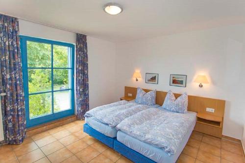 1 dormitorio con cama y ventana grande en Ferienwohnung Rügen-Freiheit, en Putgarten