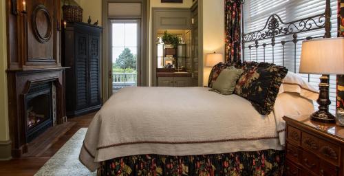 a bedroom with a large bed and a fireplace at The Chanler at Cliff Walk in Newport