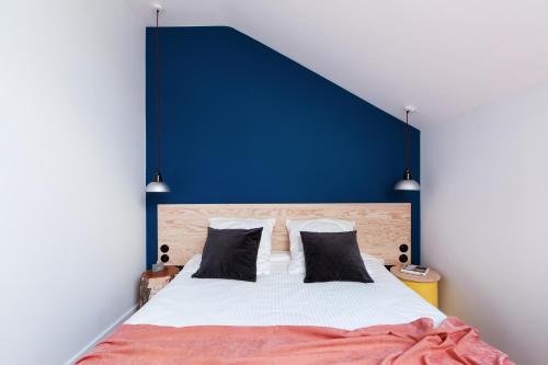 um quarto com uma cama com uma parede azul em Pokrovka 6 Hotel em Moscou