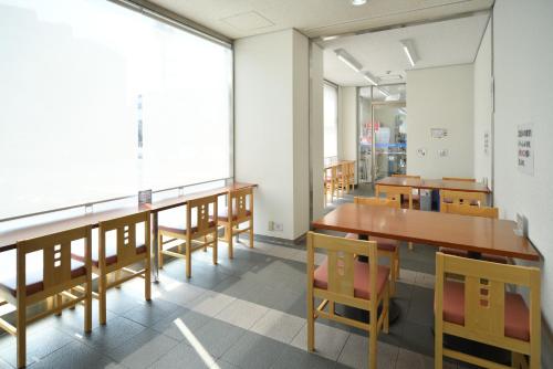 a classroom with tables and chairs and a large window at Uwajima Oriental Hotel in Uwajima