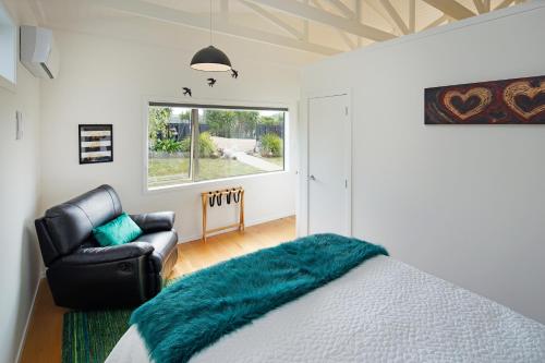 a bedroom with a bed and a chair and a window at Fairview Unit 1 in Palm Beach