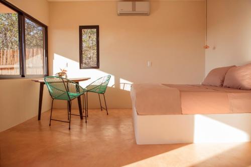 a bedroom with a bed and a table and chairs at Casa Mono in San Agustinillo