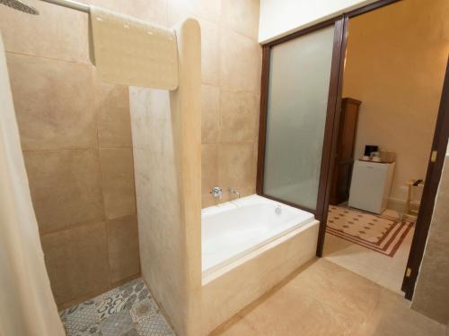 a bathroom with a bath tub and a shower at Hotel del Gobernador in Mérida