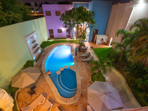 an overhead view of a swimming pool with chairs and umbrellas at Hotel del Gobernador in Mérida