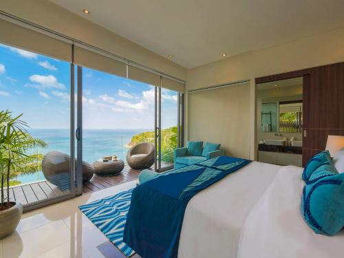 a bedroom with a bed and a view of the ocean at Villa Samira by Elite Havens in Kamala Beach