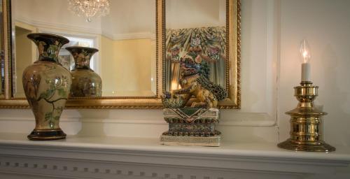 a mantel with vases and a candle and a mirror at The Chanler at Cliff Walk in Newport