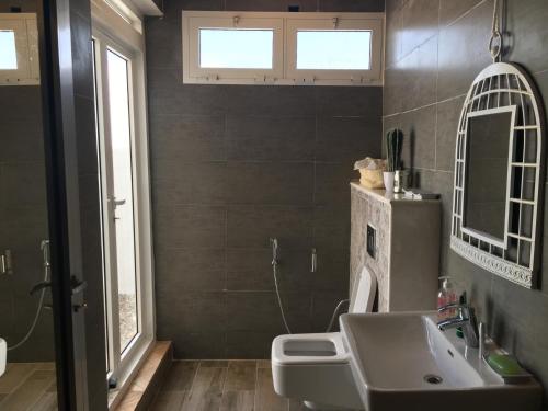a bathroom with a sink and a mirror at Ash Villa in Al Ashkharah