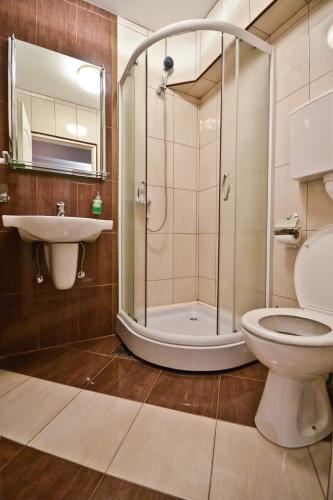 ein Badezimmer mit Dusche, Toilette und Waschbecken in der Unterkunft Apartments Imper - IMD in Niš