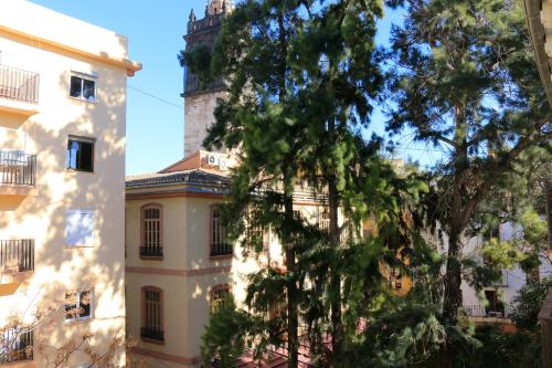 a tree in front of a building with a tower at BET Apartments - Tramontana Apartments in Valencia