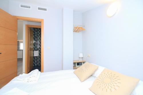 a white bedroom with a white bed with pillows at BET Apartments - Tramontana Apartments in Valencia
