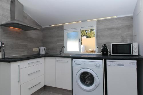 a kitchen with a washing machine and a microwave at BET Apartments - Tramontana Apartments in Valencia