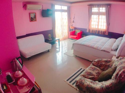 五結鄉的住宿－親水棧民宿，卧室设有粉红色的墙壁、一张床和一张沙发
