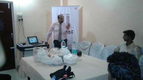 a man standing next to a table with a baby at Paul's Inn in Silchar