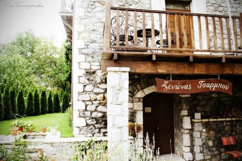 a building with a balcony on top of it at Tsarbou Guesthouse in Stemnitsa
