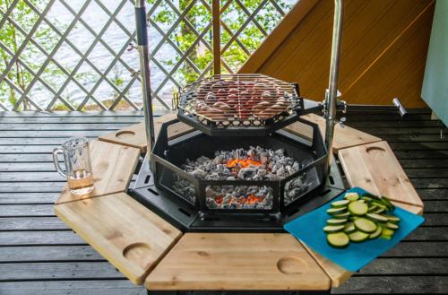 a grill on a wooden table with food on it at Villa Leppäkerttu in Enonkoski