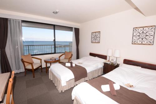 a hotel room with two beds and a balcony at Isohara Seaside Hotel in Isohara
