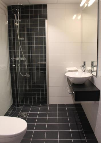 Un baño con ducha, lavabo e inodoro. en Hotell Rättvik, en Rättvik