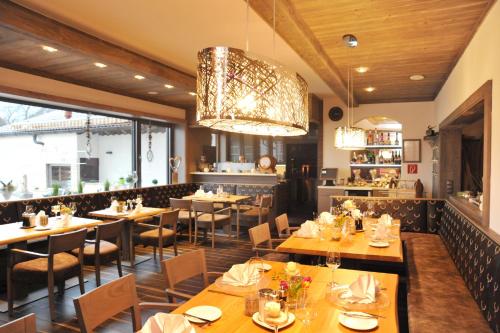 a restaurant with wooden tables and chairs and a chandelier at Bernrieder Hof in Bernried