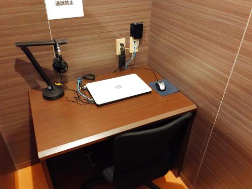 a desk with a laptop and a lamp on it at Sauna & Capsule Hotel Rumor Plaza in Kyoto