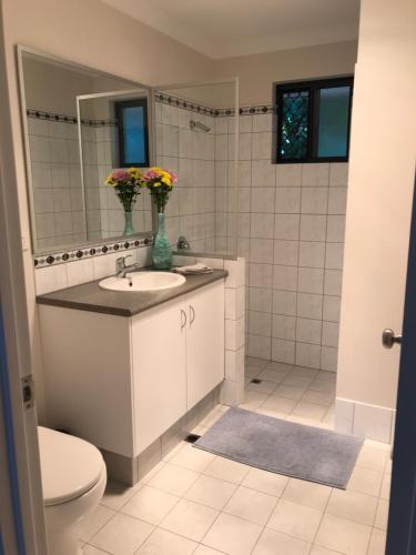uma casa de banho com um lavatório, um WC e um espelho. em Little Shangri-La em Busselton