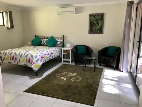 1 dormitorio con 1 cama y 2 sillas en Little Shangri-La en Busselton
