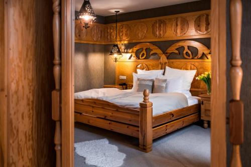 a bedroom with a large bed with a wooden headboard at Bajka Hotel & Resort in Grodziec