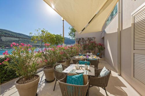 un patio con mesas, sillas y flores en Boutique Hotel Adoral en Rabac