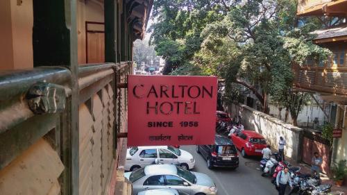 a sign for a hotel on the side of a building at Carlton Hotel Mumbai - Behind Taj Mahal Palace Colaba Mumbai in Mumbai