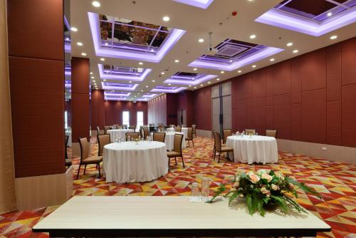 a banquet hall with white tables and chairs at Le D'Tel Bangkok in Bangkok