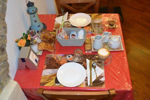 uma mesa vermelha com pratos e pratos em Hotel Major em Génova