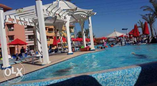 a pool at a resort with people swimming in it at Seaview Chalets in Porto South Beach - Families only in Ain Sokhna