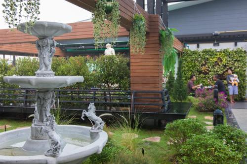 a fountain in the middle of a garden at B-your home Hotel Don Mueang Airport Bangkok 如你家酒店 in Bangkok