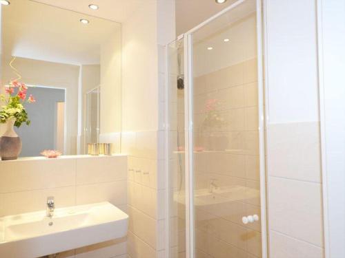 a white bathroom with a shower and a sink at Ferienwohnung-Adlerhorst in Baabe