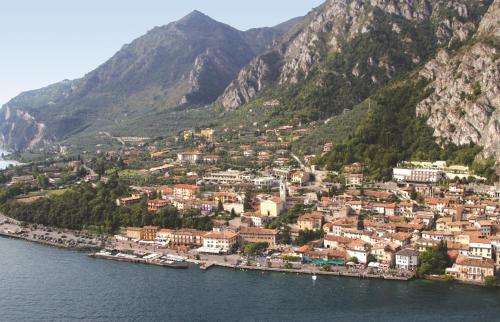 une ville sur la rive d'une masse d'eau avec des montagnes dans l'établissement Residence La Madonnina, à Limone sul Garda
