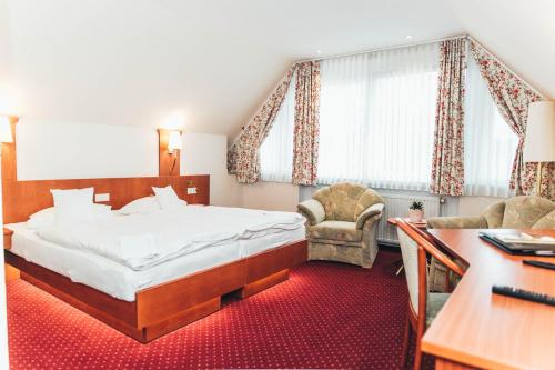 a hotel room with a bed and a desk at Ringhotel Teutoburger Wald in Tecklenburg