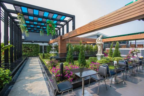 a patio with tables and chairs and a statue at B-your home Hotel Don Mueang Airport Bangkok 如你家酒店 in Bangkok