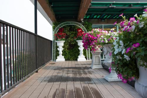 a wooden walkway with vases of flowers on it at B-your home Hotel Don Mueang Airport Bangkok 如你家酒店 in Bangkok