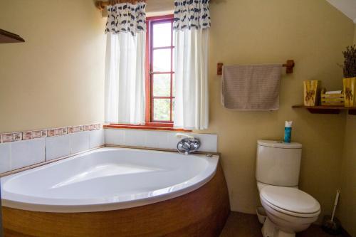 a bathroom with a large tub and a toilet at 40 Fraser Street Bed and Breakfast in Howick