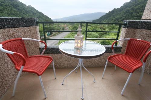 a table and two chairs on a balcony with a view at Teamilu Homestay in Datong