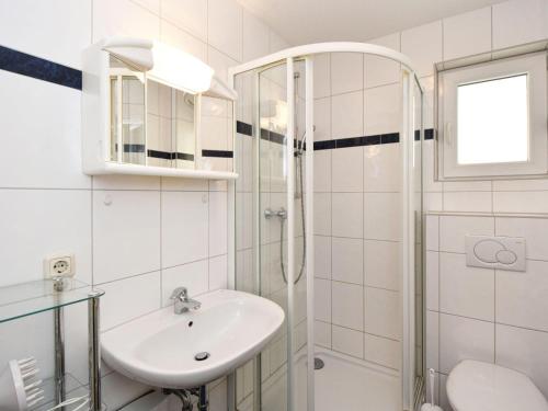 a white bathroom with a sink and a shower at Ferienwohnung-1a-7 in Baabe