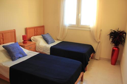 een hotelkamer met twee bedden en een raam bij Villa Romana Roquetas in Roquetas de Mar