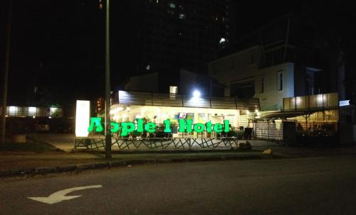 a sign that reads apole hotel at night at Apple 1 Hotel Gurney in George Town