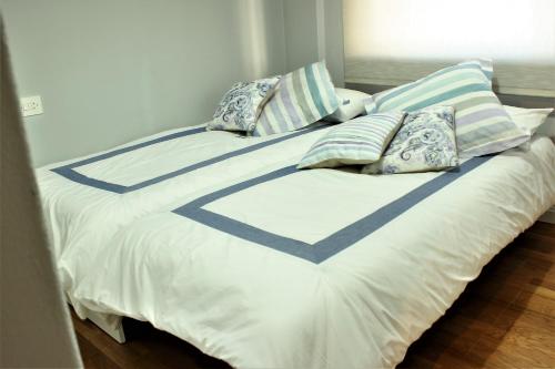 een groot wit bed met kussens erop bij Apartamento Lula in Santiago de Compostela