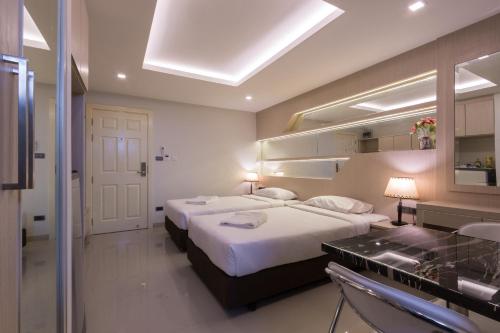 a hotel room with two beds and a sink at B-your home Hotel Don Mueang Airport Bangkok 如你家酒店 in Bangkok