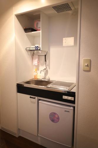 a small kitchen with a sink and a counter at Hotel Yumeya in Fukuoka